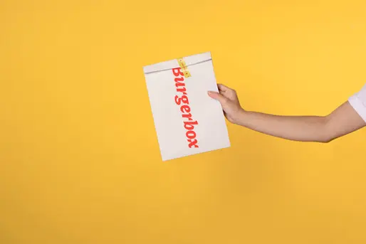 a man holding a burgerbox company package